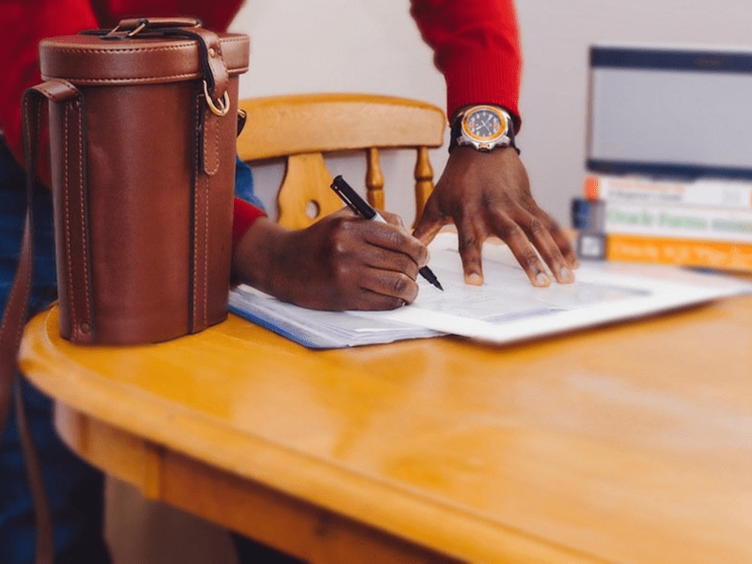 an image of a man writing at a desk