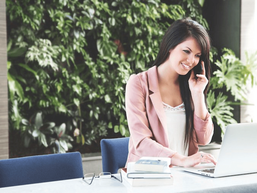 an image of a women on the phone at her desk