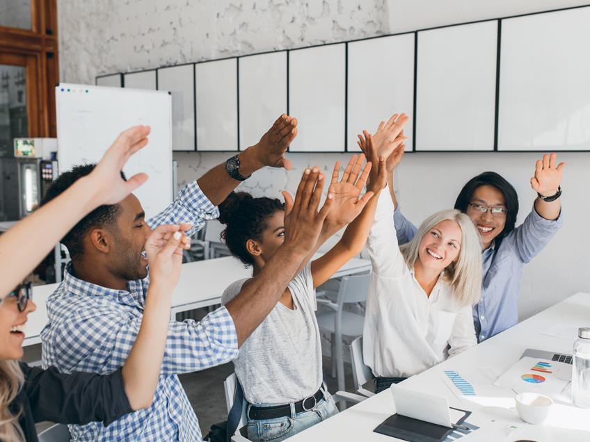 an image of happy staff with their hands in the air