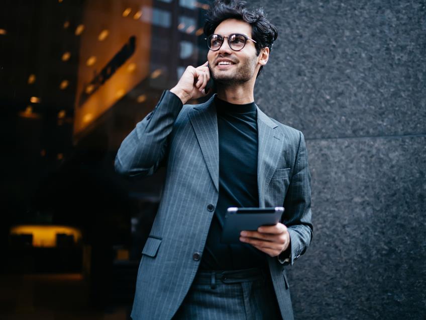 an image of a business man in the street on a phone