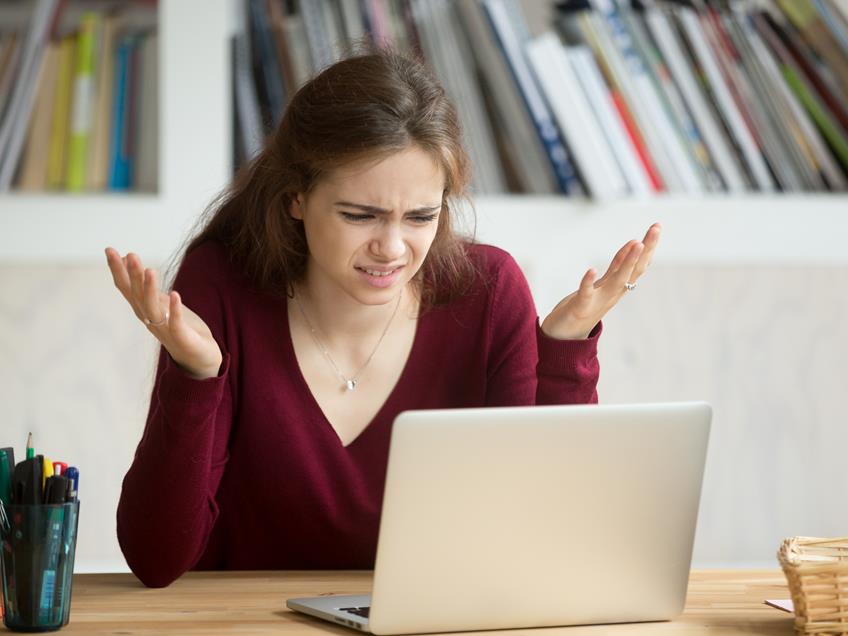 an image of a woman looking confused on a laptop